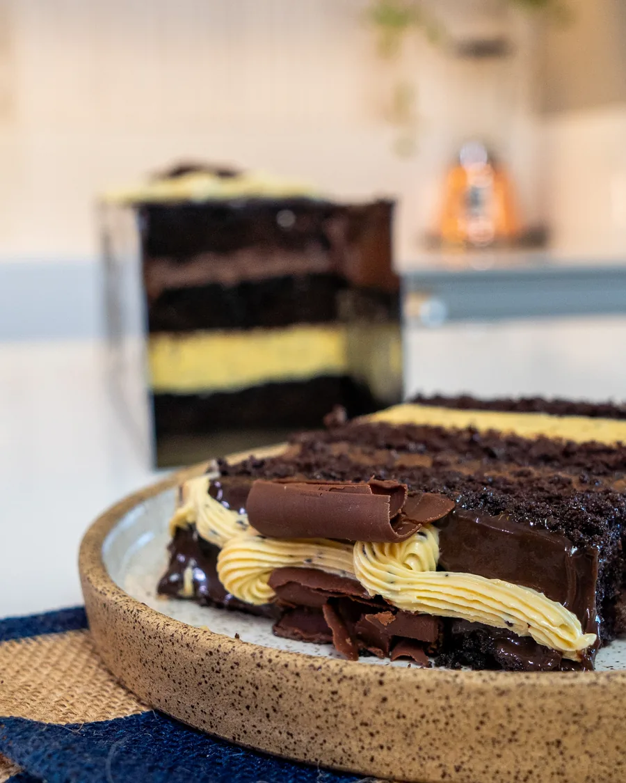 Fatia de maracuja com chocolate, com o creme amarelo entre as camadas escuras